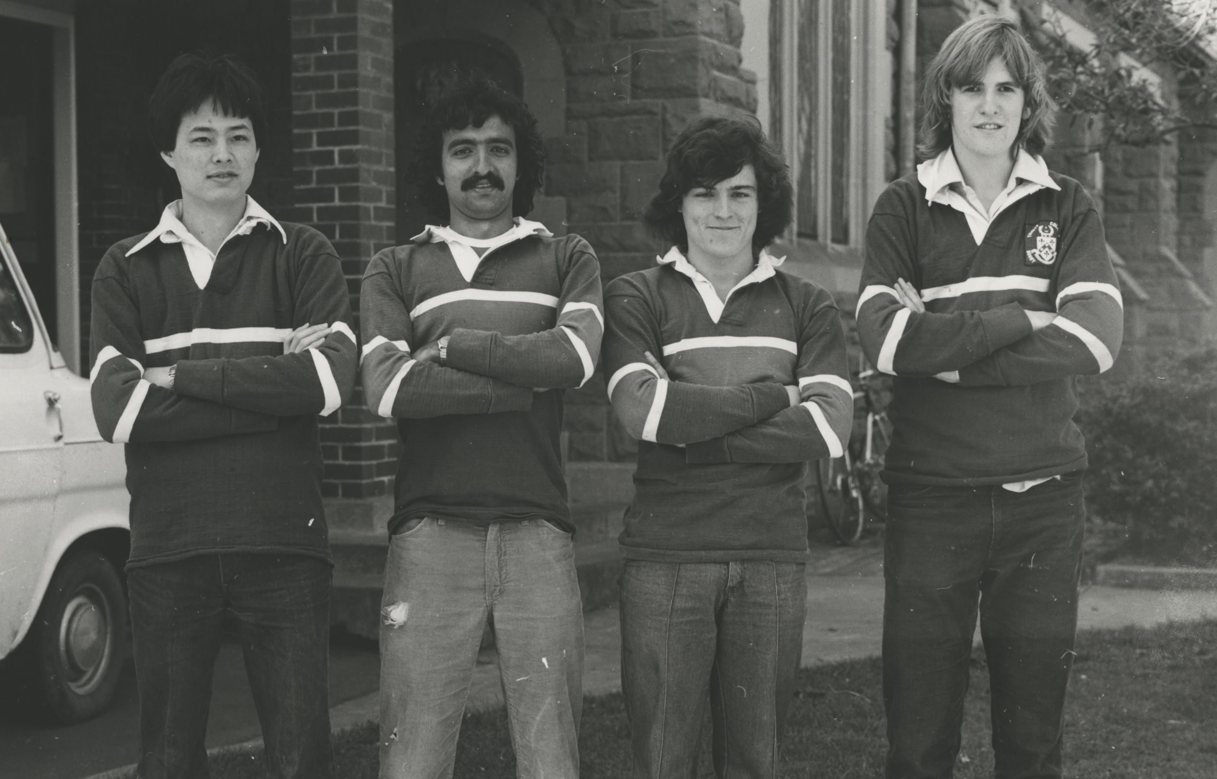 Four members of the 1980 Badminton team line up near the old entrance to the Dining Hall.